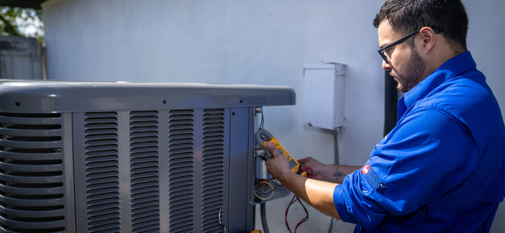 Millennium's technician conducting maintenance on an outdoor air conditioning unit.
